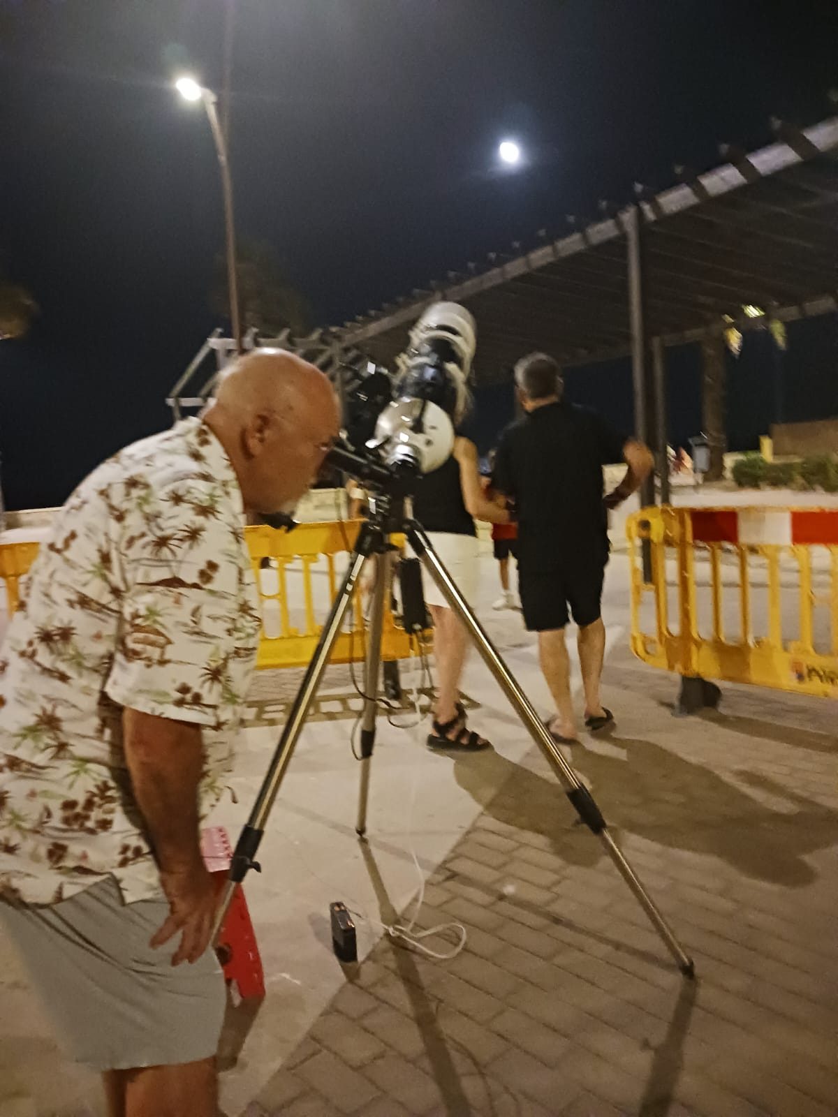 Asistente observando la Luna por el telescopio en Puzol