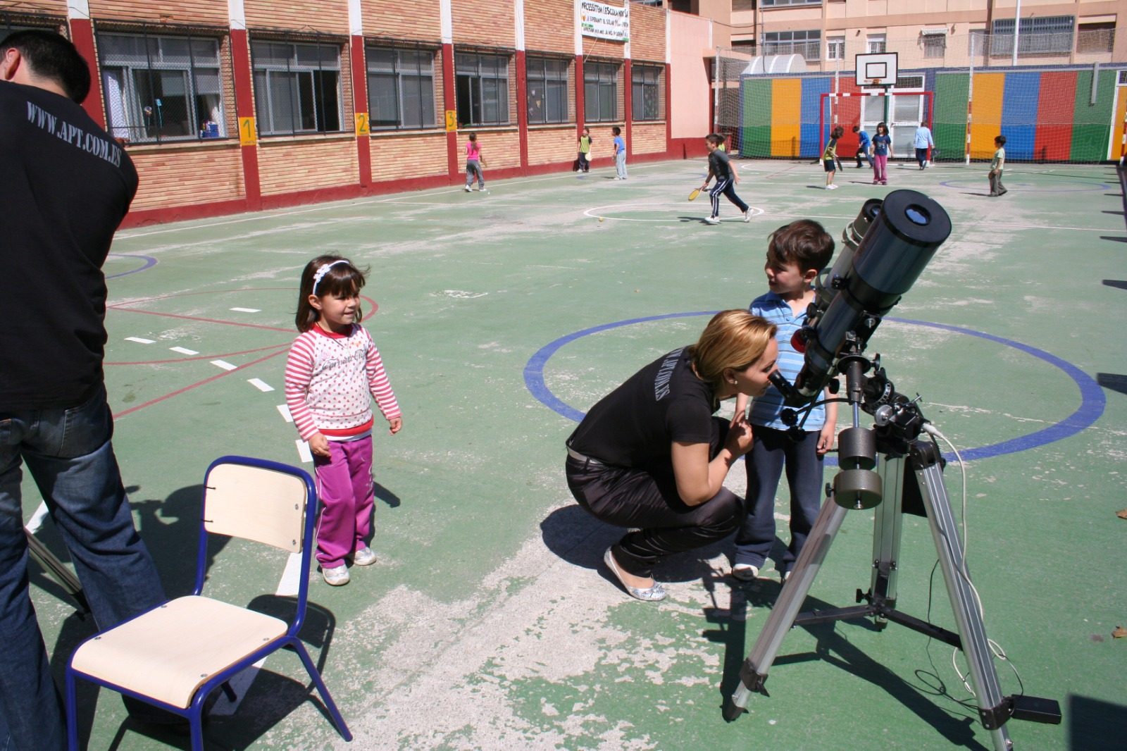 Monitora de APT enseñando el telescopio al alumnado